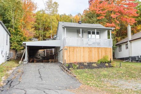 Front exterior of the house with its carport and driveway in autumn