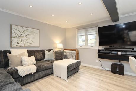 Living room with a grey sectional and wall-mounted TV