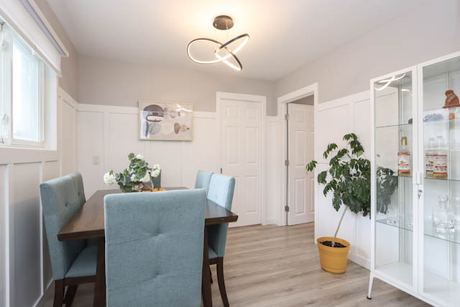 Dining area with blue upholstered chairs and white display cabinets