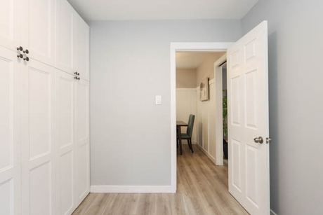 Small room with built-in white cabinets and a doorway to the dining area