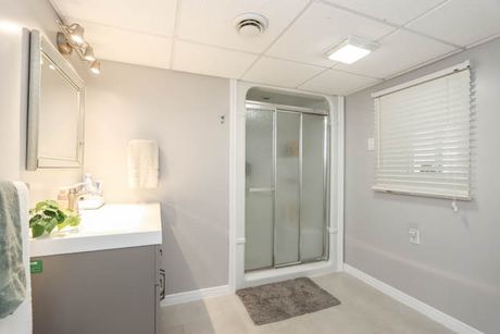 Bathroom with glass shower, vanity and mirror