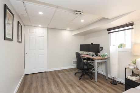 Lower-level room set up as an office with a desk and window