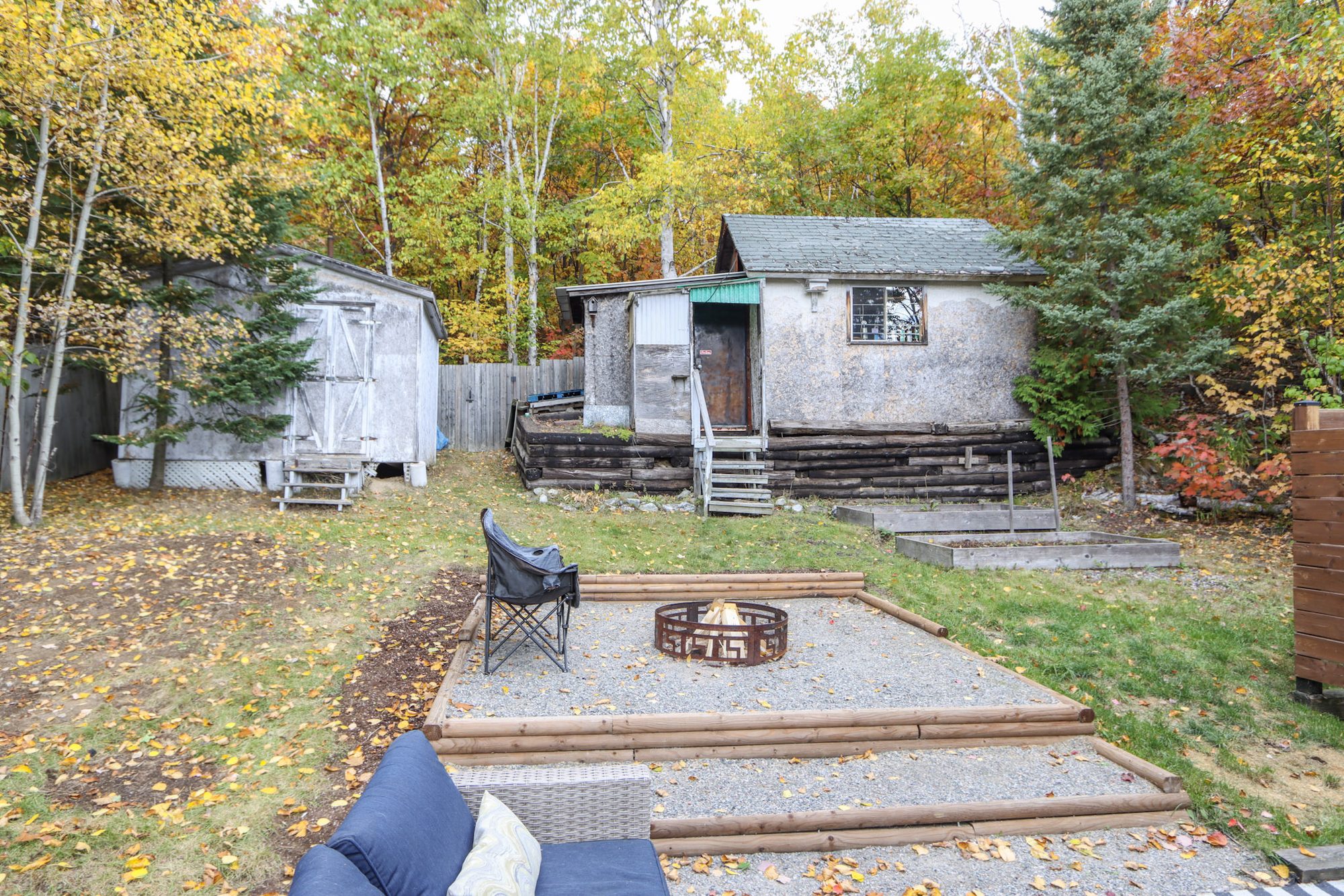 Backyard with a shed, fire pit area and wooden stairs