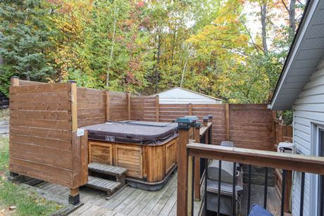 Hot tub on the back deck beside wooden privacy fencing